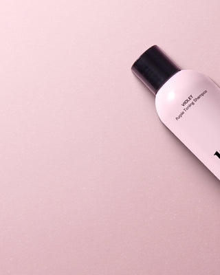 Two pink bottles of hair care products labeled "l'ange," set against a matching pink background.