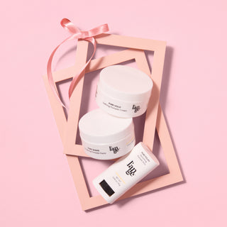 L’ange hair styling products (pomades) arranged with decorative frames and ribbon on a pink background.