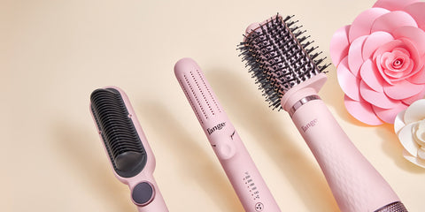 A close up of 3 hair tools and flowers in the background that are pink and white. 
