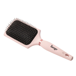 A pink paddle brush sits diagonally in a white background, displaying the logo & cushioned bristles.