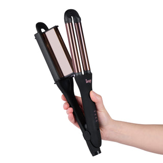 A hand holding a black and rose gold hair styling tool with dual barrels and a flat plate.