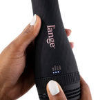 Black tear-drop brush dryer with temperature twist handle held by dark skin hand