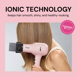 Pink L’ange hair dryer with a comb attachment being used on straight blonde hair, featuring text “Ionic Technology – Keeps hair smooth, shiny, and healthy-looking” with a pink badge that says “Powered by Ions"