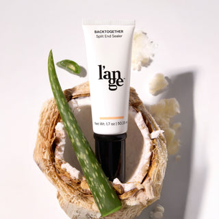 L’ange BackTogether Split End Sealer tube standing in a cracked coconut shell with aloe vera