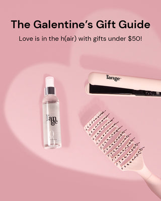Three hair tools laid flat on a pink surface outlining a light pink heart over a mauve background. A message highlighting a galantine's gift guide with gifts under $50 displayed above.