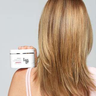 Model holding masque from behind with an image of the hair 