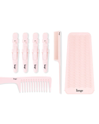 Set of pink hair accessories including four styling clips, a fine-tooth comb, a wide-tooth comb, and a textured mat.