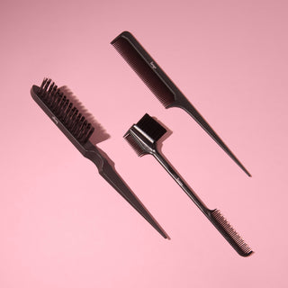 Black L’ange carbon fiber combs and brushes arranged on a pink background.