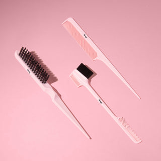 Black L’ange carbon fiber combs and brushes arranged on a pink background.