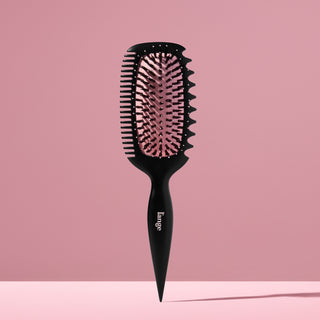 L’ange Curl Sculptor brush standing upright against a pink backdrop