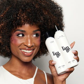 Model holding Curl Care Shampoo & Conditioner.