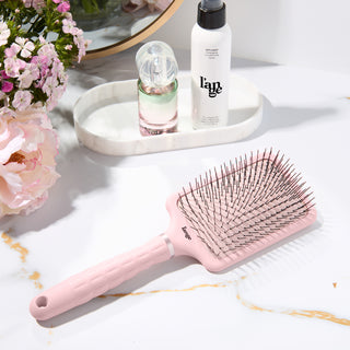 detangling padding brush with nylon bristles on a vanity