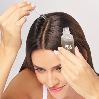 Model applying Detox serum to scalp.