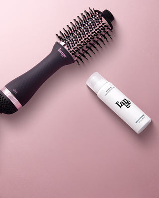 Value Set. L’ange hair products laid flat on a pink background including Le Volume 60mm (Black) and glass hair