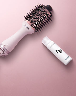 Value Set. L’ange hair products laid flat on a pink background including Le Volume 75mm (Blsuh) and glass hair