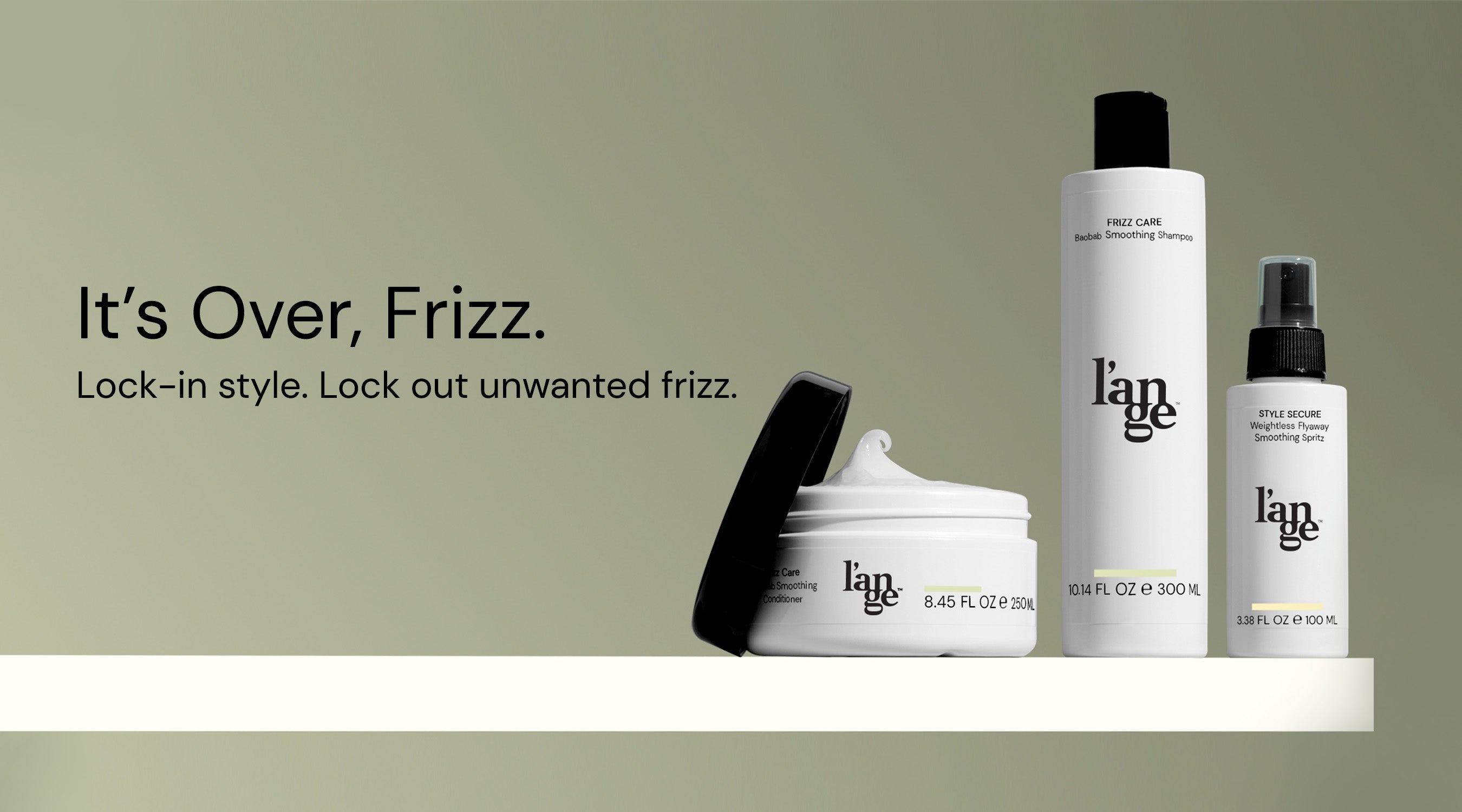 Hair care products from l'ange, including a smoothing shampoo, conditioner, and flyaway smoothing spritz, set against a green background with the text "It's Over, Frizz. Lock-in style. Lock out unwanted frizz."