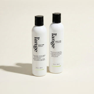 L'ange Frizz Care Shampoo and Conditioner bottles on a beige background