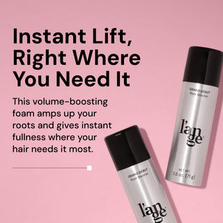 Two silver bottles of L’ange Grand Début Root Booster with black caps are displayed on a pink background. Bold black text reads “Instant Lift, Right Where You Need It,” followed by smaller text: “This volume-boosting foam amps up your roots and gives instant fullness where your hair needs it most
