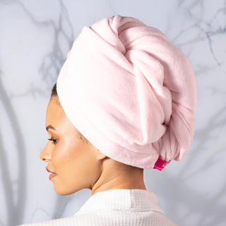 Woman with blush hair wrap towel around her head