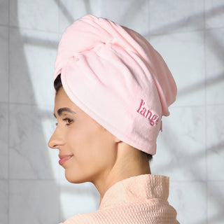 Woman with blush hair wrap towel around her head