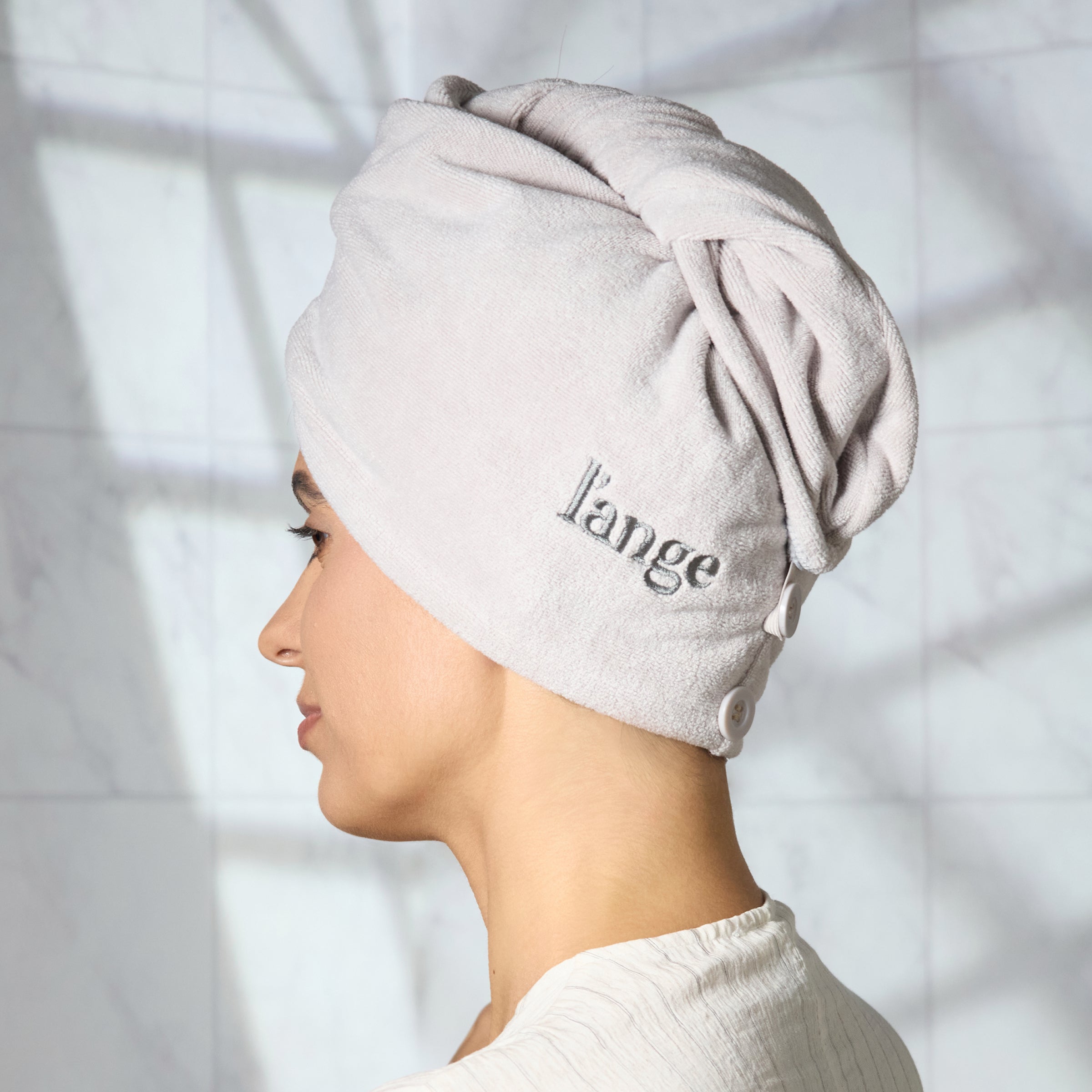 Woman with gray hair wrap towel around her head
