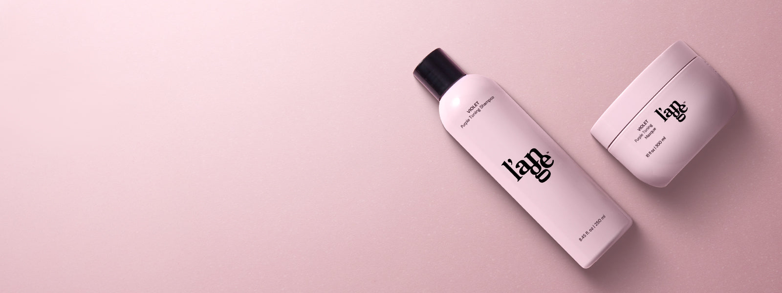 Two pink bottles of hair care products labeled "l'ange," set against a matching pink background.