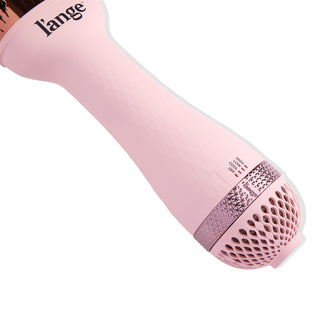A pink hair dryer with textured grip and multiple heat settings displayed near the base.