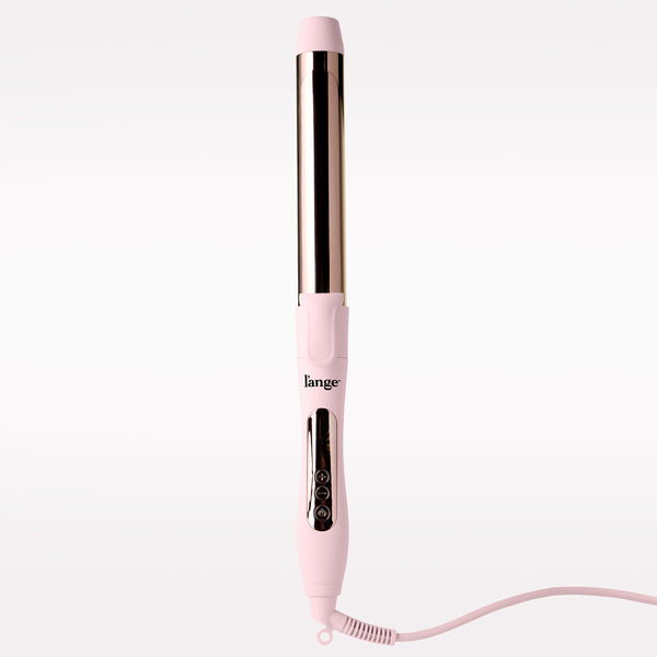 A pink L'ange curling iron with a metallic rose gold barrel, shown vertically on a clean white background with its cord extending to the right.