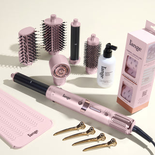 The Bombshell Blowout Value Set, featuring a Blush TurboStyle, Gloss Shock, Thermal Hair rollers, Heat resistant mat, and precision metal sectioning hair clips, displayed on a beige background