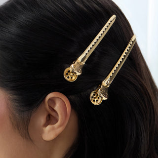 Model wearing gold precision metal hair clips in dark hair, side view.