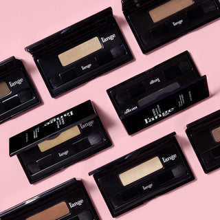 Assorted l’ange RootMatch compacts and boxes arranged on a pink background, showing multiple shade options