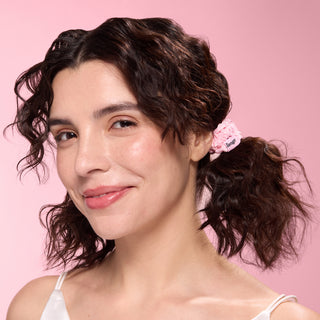 model with two ponytails secured by small blush satin scrunchies