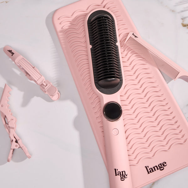 Smooth-It on a vanity with a heat-resistant mat and hair clips and a comb.  