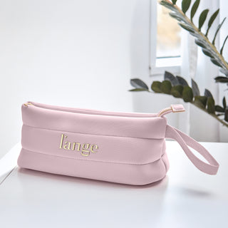 Blush L’ange zippered cosmetic bag with gold logo and wrist strap on a white surface.