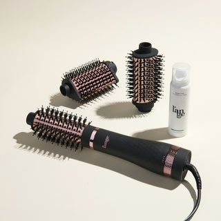 The Switch It Up Value Set, featuring a Black Multi-Volume Series Brush, 65mm and secondary attachments, and Glass Hair, displayed on a beige background.