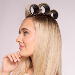 model with thermal hair rollers secured at the crown of her head