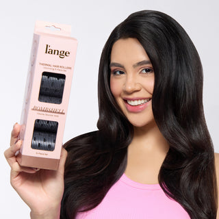 A smiling model with dark hair holding a pink L’ange Thermal Hair Rollers box