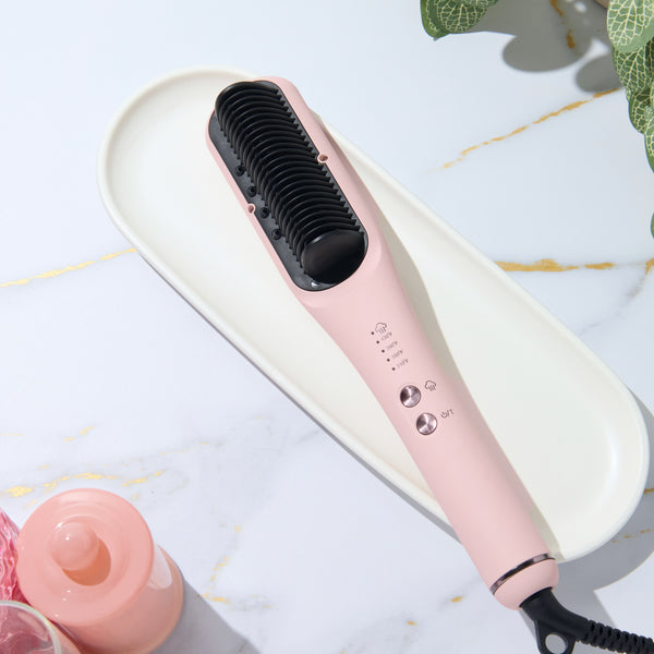 Blush SteamSmooth heated straightening brush on a marble vanity tray