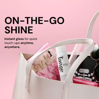 L’ange Top Coat shine spray inside a handbag. Text reads "ON-THE-GO SHINE. Instant gloss for quick touch-ups anytime, anywhere"