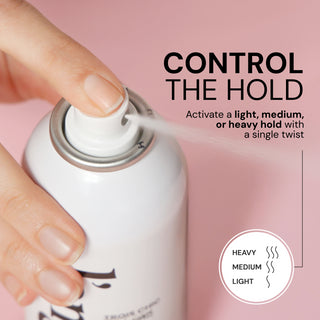 Close-up of a hand pressing the nozzle of a L’ange hairspray can releasing a fine mist on a pink background. Text reads: “CONTROL THE HOLD. Activate a light, medium, or heavy hold with a single twist.” A graphic icon reads: “HEAVY / MEDIUM / LIGHT.”