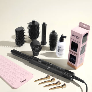 The Bombshell Blowout Value Set, featuring a Black TurboStyle, Gloss Shock, Thermal Hair rollers, Heat resistant mat, and precision metal sectioning hair clips, displayed on a beige background