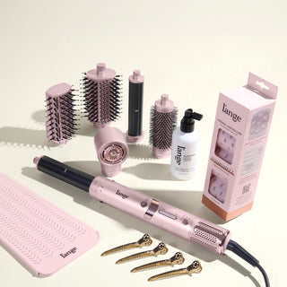 The Bombshell Blowout Value Set, featuring a Blush TurboStyle, Gloss Shock, Thermal Hair rollers, Heat resistant mat, and precision metal sectioning hair clips, displayed on a beige background