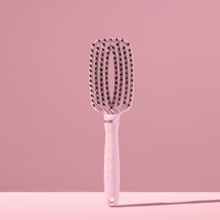 blush L’ange vented paddle brush with nylon bristles standing upright on pink background