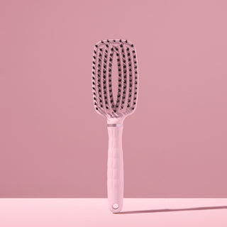blush L’ange vented paddle brush with nylon bristles standing upright on pink background