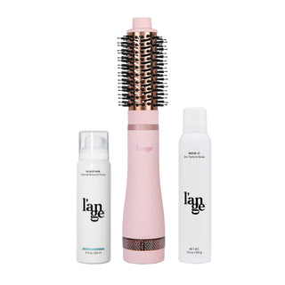 Pink and black hair styling tool flanked by a bottle of thermal blowout primer and a bottle of dry texture spray, all bearing the same brand logo.