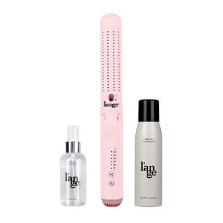 Pink hair straightener accompanied by a transparent spray bottle and a compact can of dry shampoo, all labeled with the same brand logo.