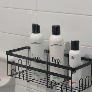 Woman applying hampoo and conditioner to hair in the shower