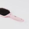 Zoomed in video of Blush Siena Paddle Brush features black bristles with boar with black L'ange logo