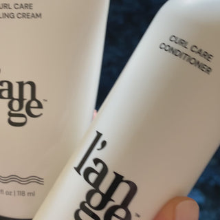 Brunette woman washing her hair with Curl Care shampoo, Curl Care Conditioner and Curl Care cream