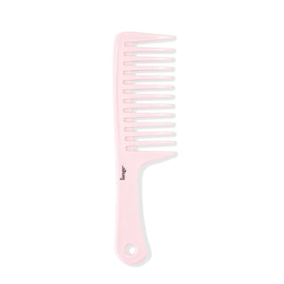 The pink detangling comb stands vertically, showing its widely-spaced teeth and flat handle.
